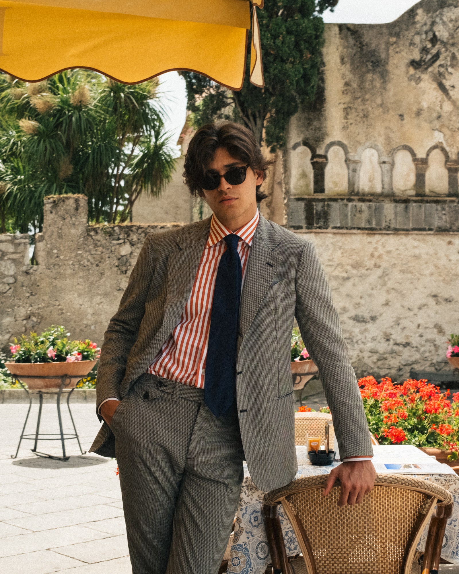 Image may contain Blazer Clothing Coat Jacket Plant Potted Plant Formal Wear Suit Pants Face Head and Person